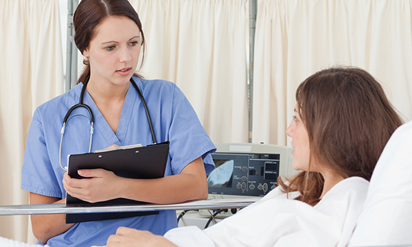 nurse at woman's bedside