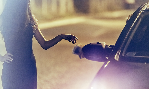 woman receives money from man in a car