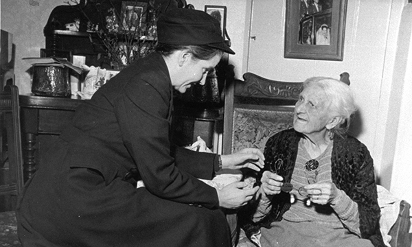 old photo of nurse attending patient in their own home