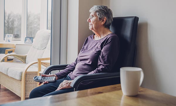 woman sits staring in a empty room