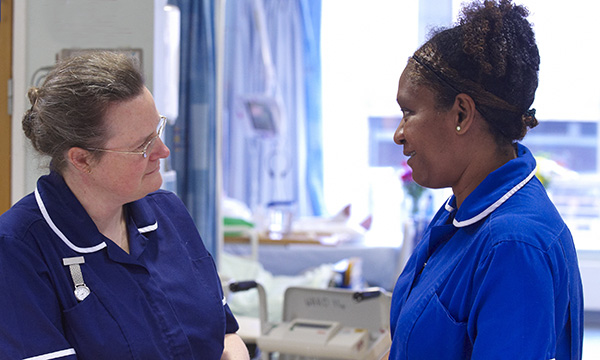 A nurse asks another about their well-being