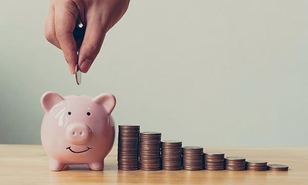 Piggy bank with coins piled up as unions demand pension rule change for nurses