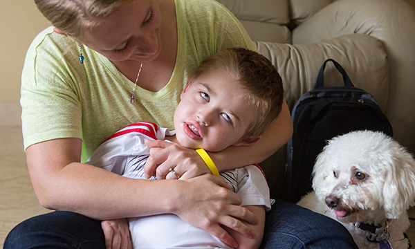 A woman embraces her five year old son, who has been diagnosed with Batten disease 