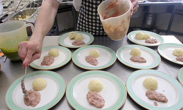 Portions of easy to swallow hospital food are put on plates