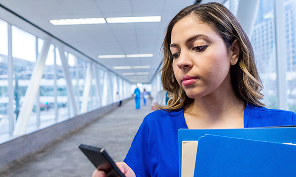 A nurse using her smart phone to access social media