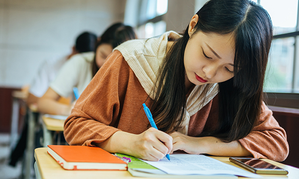 young woman sits a written test