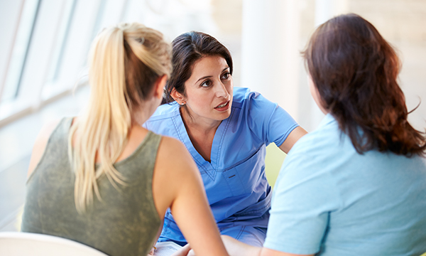 A nurse talks to a teenager moving to adult services and her mother