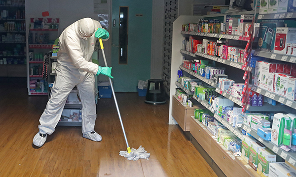 Man in protective clothing cleaning the County Oak Medical Centre in Brighton