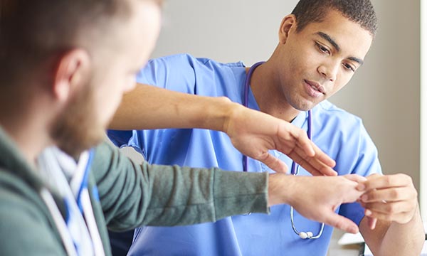 man extends arm out to be assessed by a nurse
