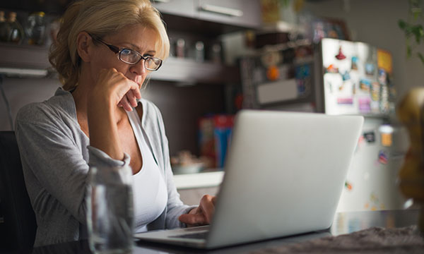 A woman looking at a computer. Please take a moment to fill in our online survey on workplace PPE. Picture: iStock
