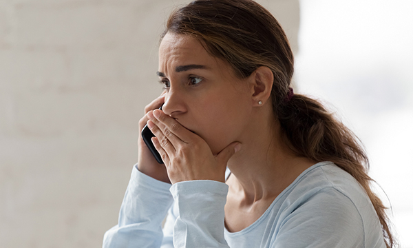 Picture shows a woman looking anxious and speaking on a phone. Two mental health trusts in London have set up round the clock mental health emergency departments that patients in crisis can reach by phone during the pandemic.