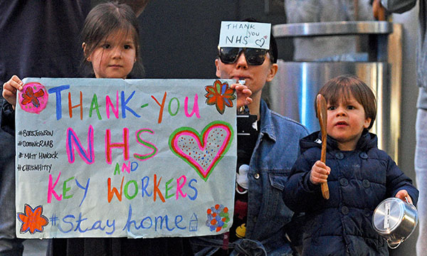 Picture shows people outside a London hospital joining the Clap for Carers. Applauded for now as among the nation’s heroes, nurses must prepare for a new fight over pay in the aftermath of COVID-19.