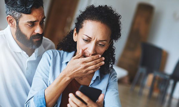 Image shows a nurse receiving abuse from on her phone from online trolls 