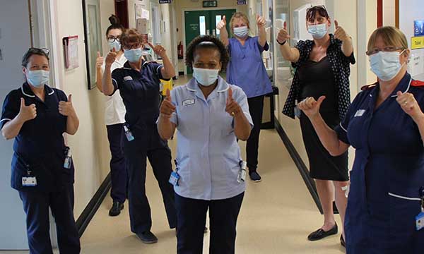 Millie Magadlela flanked by colleagues on her first day back at work