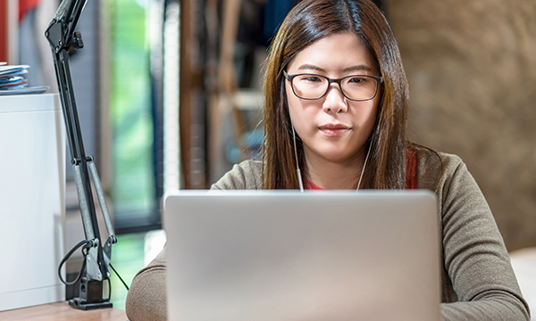 Picture shows a young woman looking at a computer screen