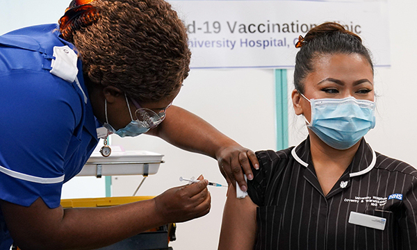 Picture shows a nurse vaccinating another medic