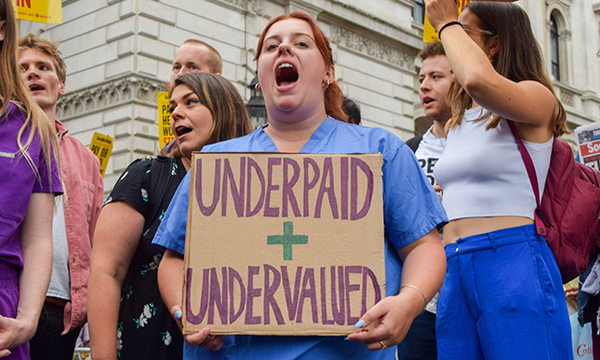Nurses hold banners calling for better pay during march in London