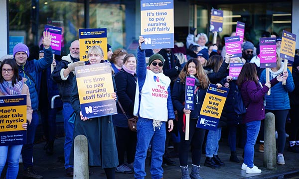 Striking nurses on an RCN picket line near Cardiff University Hospital hold placards that call for better pay 