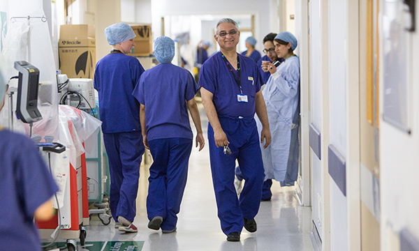 Nurses in a hospital corridor, a smiling nurse facing the camera