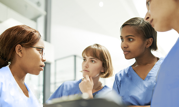 An emergency department nurse leads a team debrief following a significant event