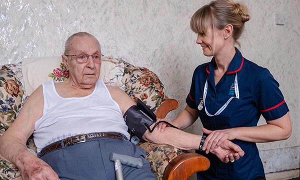 Advanced clinical practitioner Briony Hawkins carrying out health checks on an older person in their home in Bristol