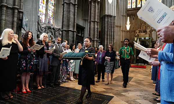 Nurse May Parsons carrying the George Cross at the start of the service at Westminster Abbey