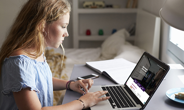 Photo of person using laptop, illustrating story about nursing degree applications falling