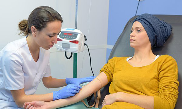 A nurse administering chemotherapy to a patient: Macmillan Cancer Support has called for urgent action from government to boost nurse numbers in cancer care