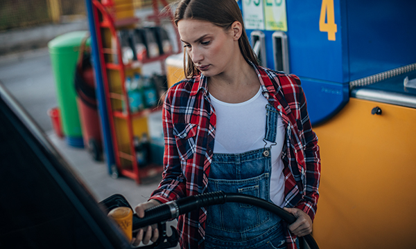 Woman fills car with petrol – NHS mileage rates fail to keep pace with petrol price inflation