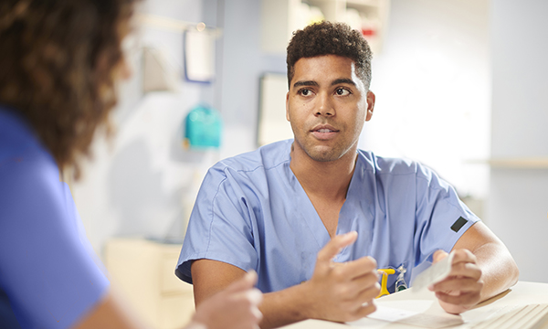 Photo of nurse talking to colleague, illustrating story about whistleblowing