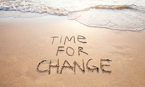 Time for change written in sand on a beach