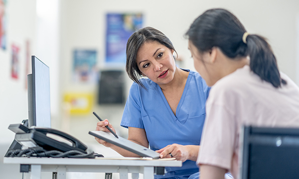 General practice nurse in discussion with a patient. GPNs are seeing delays in delivery of their pay awards