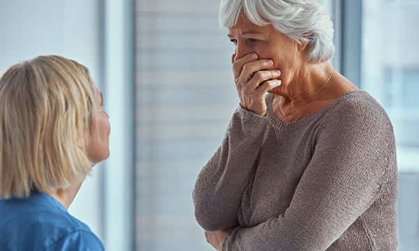 A hospital nurse breaking bad news to a woman about her loved one