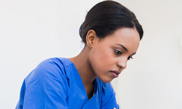 A nurse sitting on her own looking sad and upset