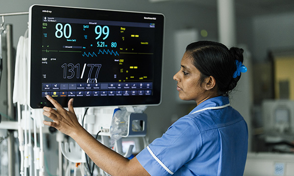 Photo of nurse analysing a clinical display screen, illustrating story about whether nurses' clinical skills are valued enough