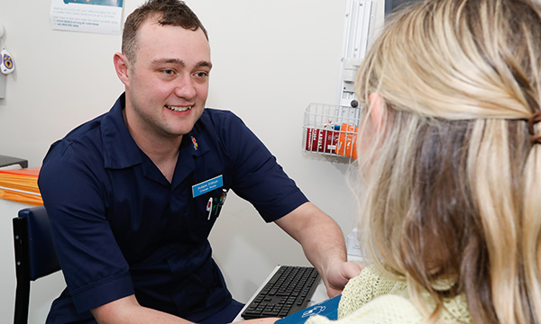 A male nurse with patient, illustrating story about low percentage of male nurses in UK