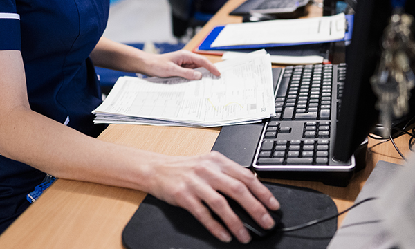 Photo of nurse entering records onto computer 