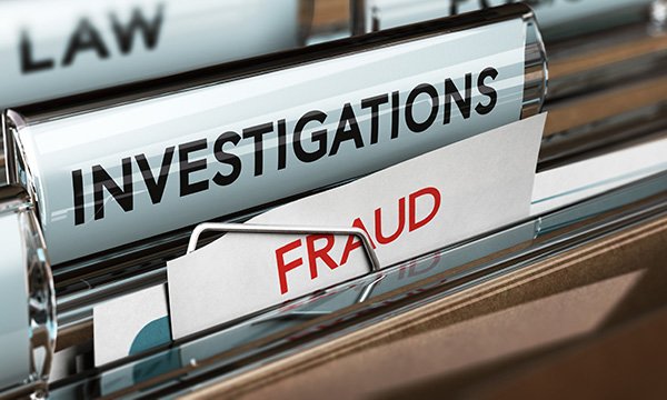 Office filing cabinet drawer is open, revealing files marked ‘investigations’ and ‘fraud’, to illustrate nurses’ removal from NMC register because of test centre fraud