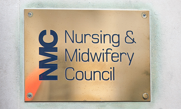 A brass name plaque at the entrance of the NMC headquarters