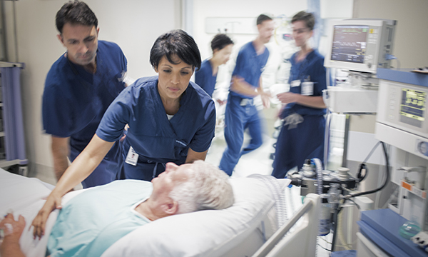 Nurses in a hospital room at the bedside of a patient diagnosed with septic shock