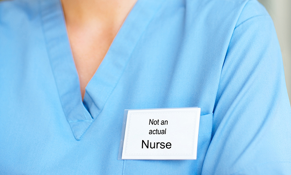 NHS support staff can have job titles that suggest they may be registered nurses. Image shows a badge that reads 'not an actual nurse', worn by someone in a blue uniform