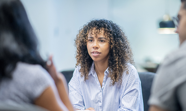NHS sickness absence: a nurse looks apprehensive as she faces two people at a formal meeting