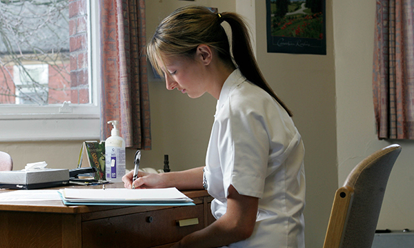 Reflective journalling: a nursing student writing at a desk, as if keeping a journal to process difficult events and record positive experiences
