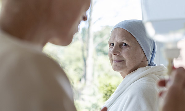 End of life care: a patient looking reassured as a nurse monitors their intravenous drip