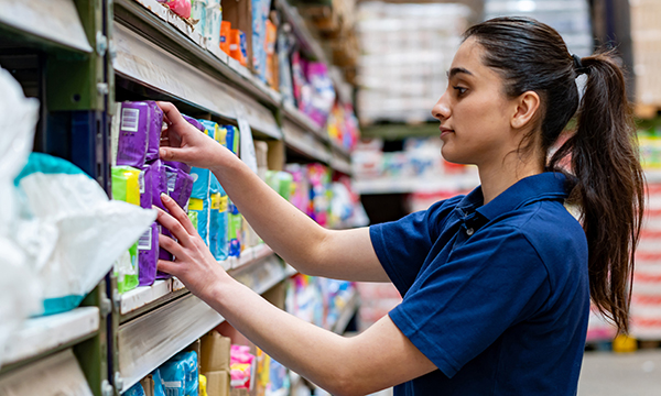 Nursing students working part-time in supermarkets: a young woman stacking shelves in a supermarket 
