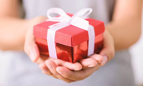 Patients’ gifts for nurses: a small gift-wrapped box being offered in a person’s cupped hands