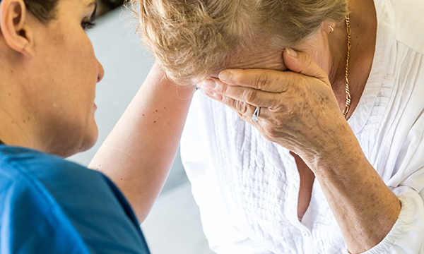 Breaking bad news: a nurse comforts a patient’s relative after breaking bad news about their care