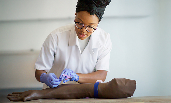 Education grants: a healthcare support worker practises phlebotomy