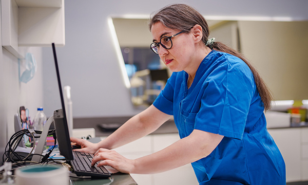 Patient records: a nurse accesses patient information on a computer in a ward setting