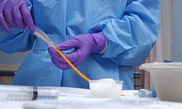 Aseptic technique: a healthcare professional working in a clinical setting wearing personal protective equipment